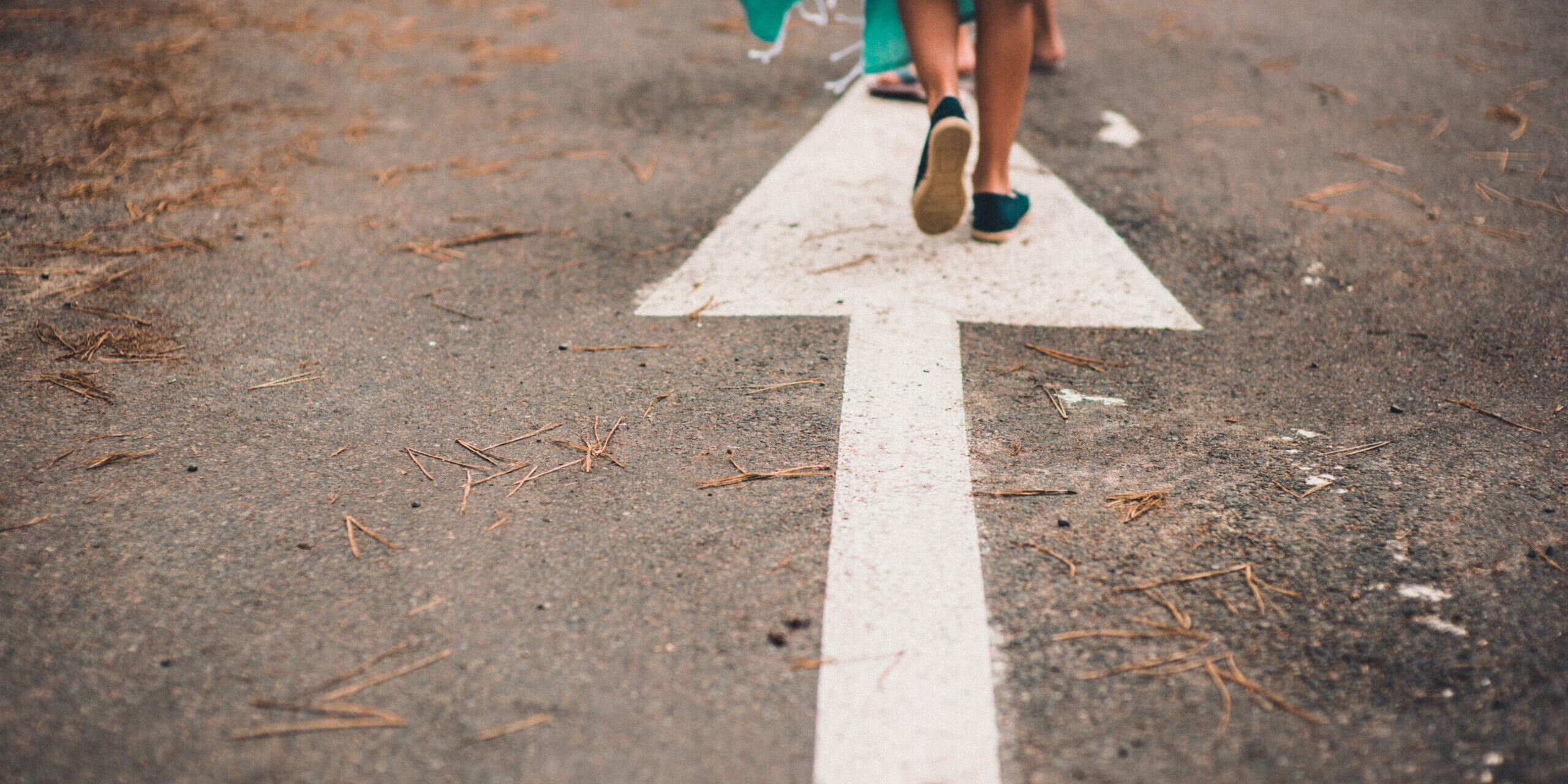 Feet_on_a_road_arrow_Unsplash