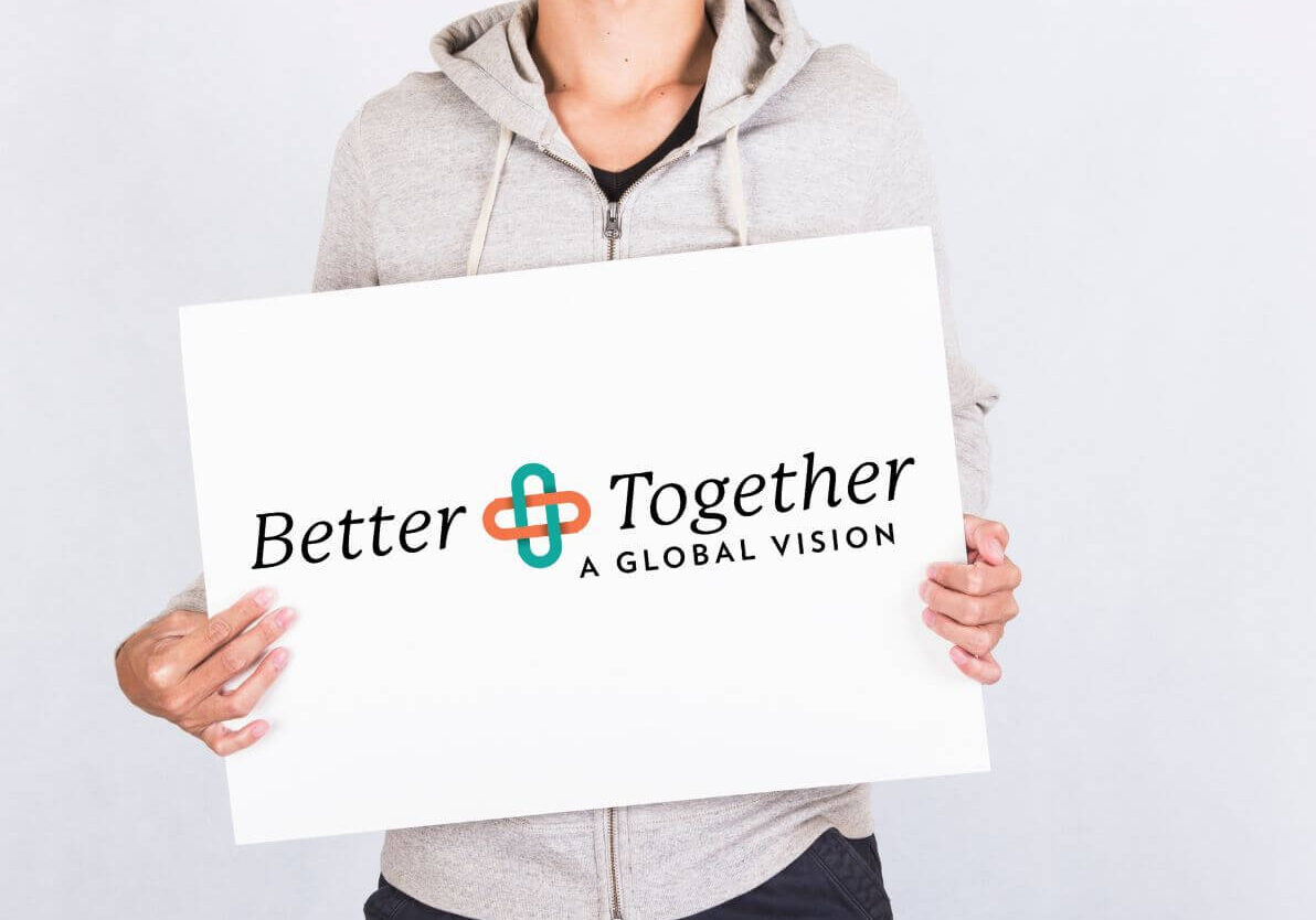 man holding sign that says better together