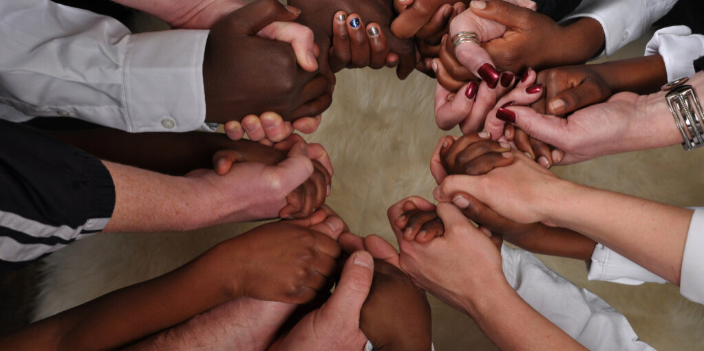 Black and white hands forming a circle.